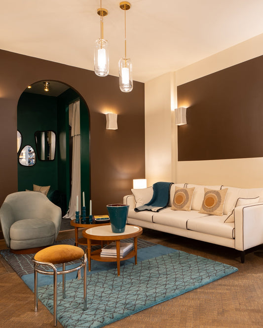 Salon en boutique : Canapé Noa écru, fauteuil vert d'eau, tabouret chromé et tapis bleu