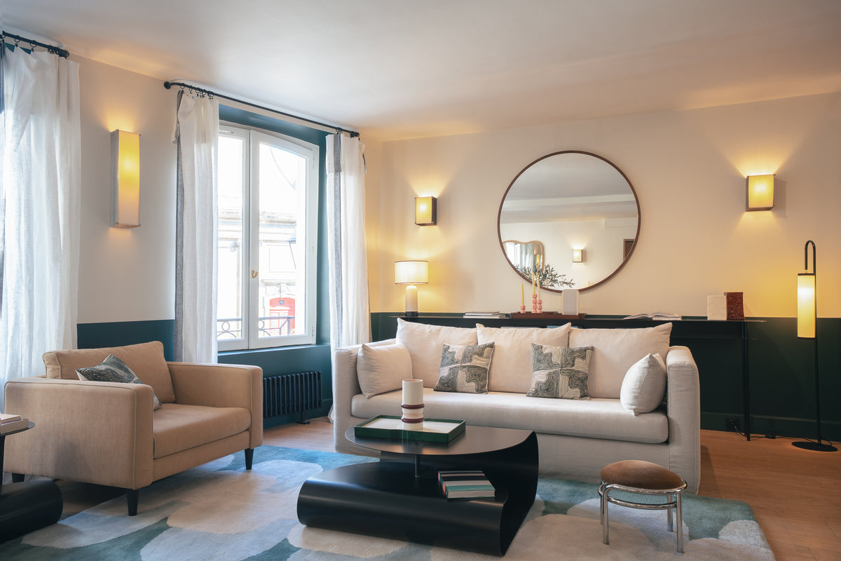 Salon en boutique : canapé écru, fauteuil beige, Miroir Bulle Noyer et table basse noire